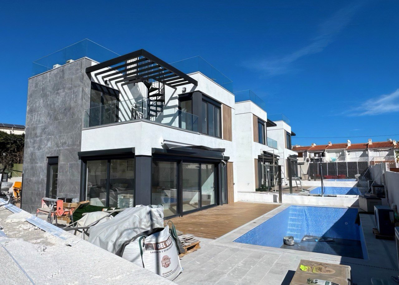 fachada de villa con ventanas panorámicas y acceso abierto al exterior