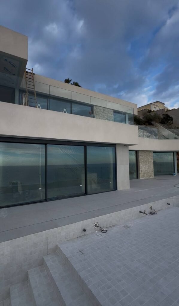 Ventanas panorámicas de gran formato con vista al mar en vivienda en pendiente