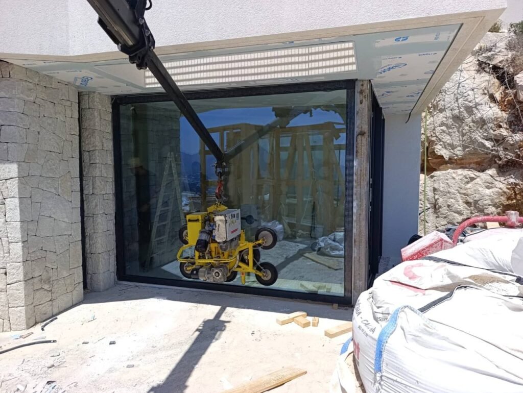 Instalación de acristalamiento panorámico con maquinaria especializada en villa de lujo en Altea Hills