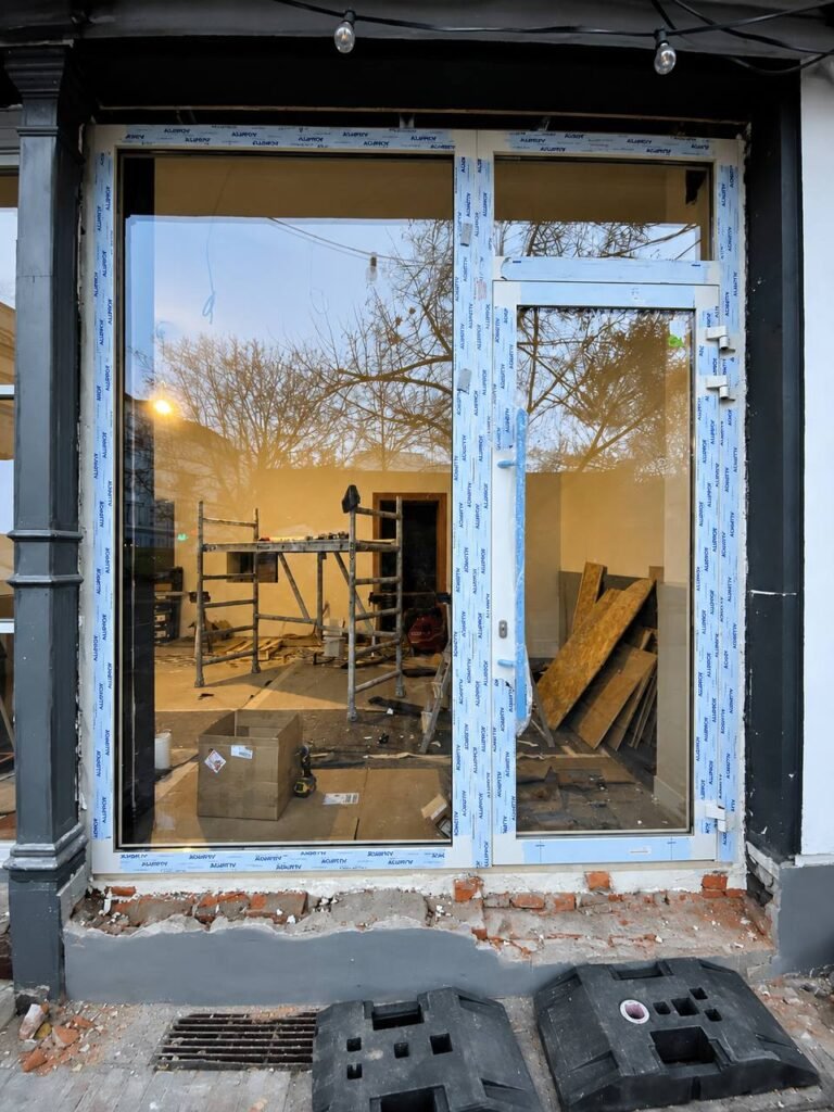Sistema guillotina automatizado de vidrio en fachada de restaurante en Berlín
