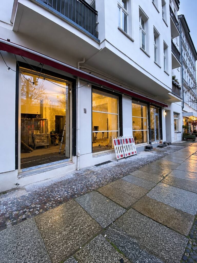 Fachada moderna de restaurante con grandes superficies acristaladas y perfiles oscuros