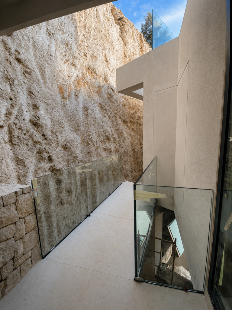 Barandillas de vidrio arquitectónicas integradas en villa contemporánea sobre la costa