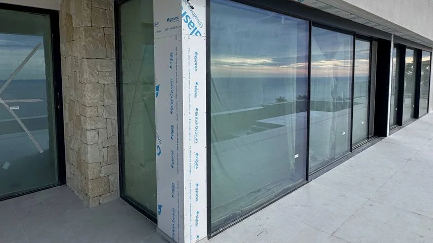 Ventanas de gran formato con perfiles oscuros en una villa con vistas al mar en la Costa del Sol
